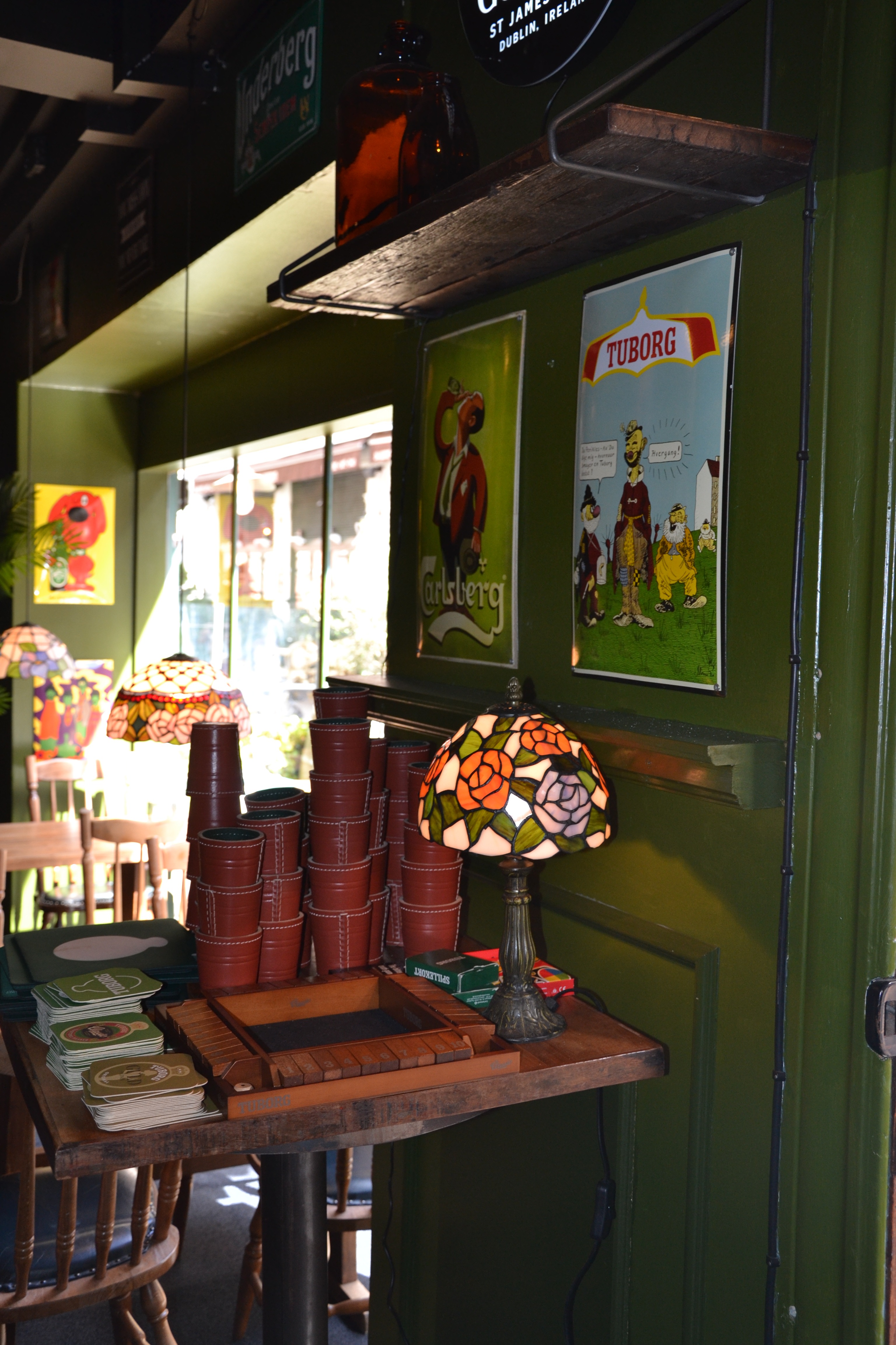 Hyggelig pub-atmosfære med vintage øl-reklamer og Tiffany-lamper